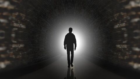 Verschwörung Ein Mann läuft in einem Tunnel, an dessen Ende icht erscheint.